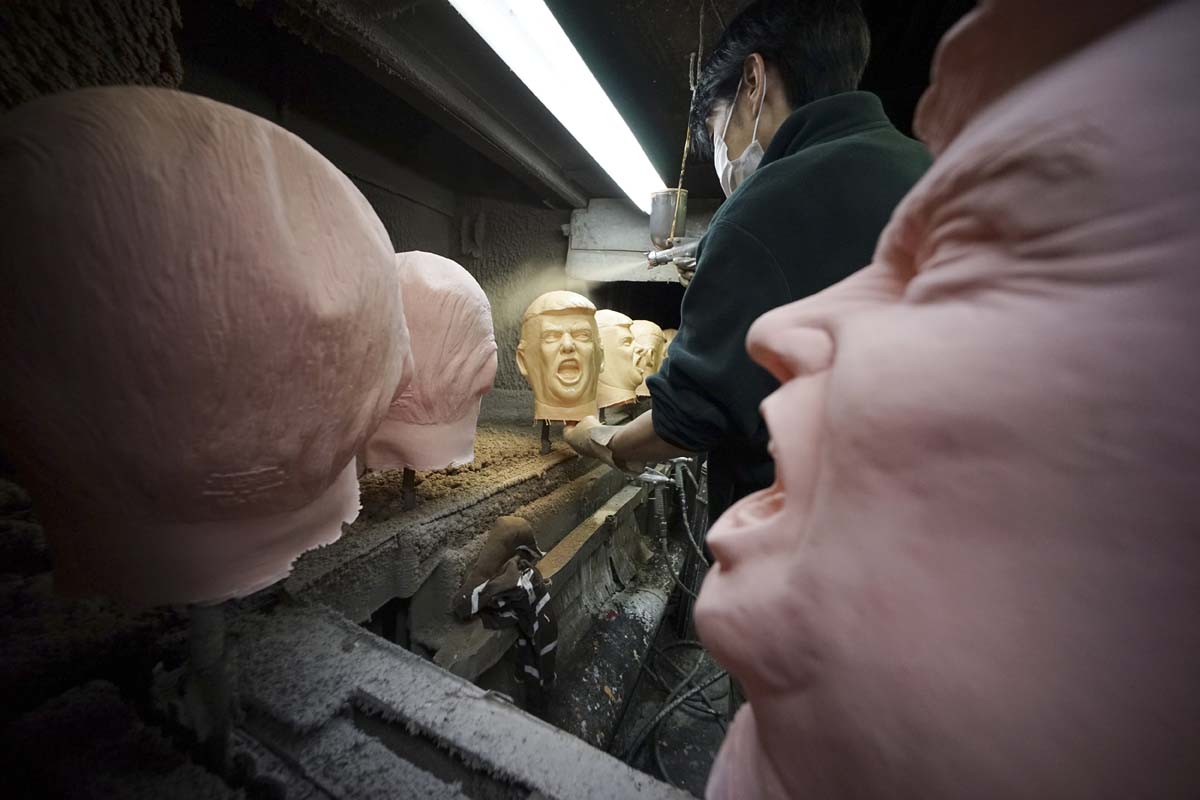 A worker sprays color on rubber masks depicting President-elect Donald Trump on a production line at the Ogawa Studio in Saitama, north of Tokyo, Tuesday, Nov. 15, 2016. Ogawa Studio, the only manufacturer of rubber masks in Japan, is working non-stop to catch up with a flood of orders for Trump masks since his election victory one week ago. The 23 staff are trying to produce 350 likenesses of Trump a day, up from 45 before the U.S. election, factory executive manager Takahiro Yagihara said Tuesday. (AP Photo/Eugene Hoshiko)